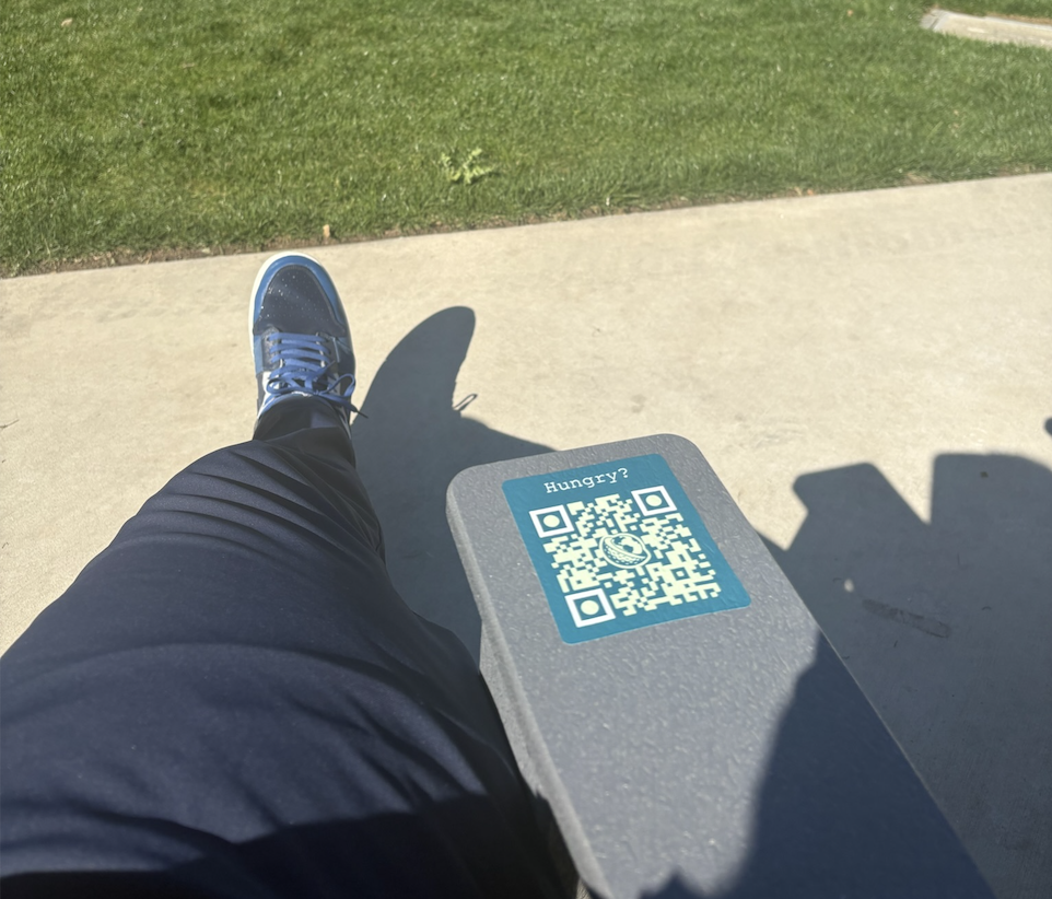 Clubhaus scan-to-order sticker with QR code on a bench near the course