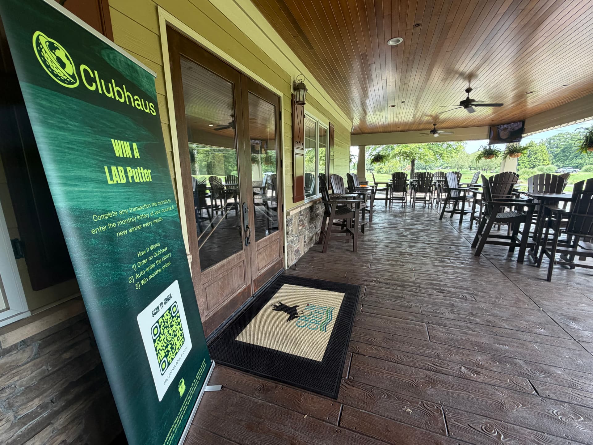Clubhaus retractable banner standing outside a clubhouse patio entrance